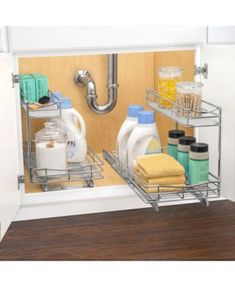 a kitchen sink with two shelves holding dishes and cleaning supplies in the bottom drawer, under a faucet