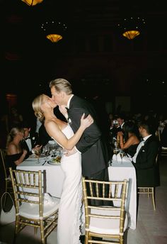 a bride and groom kissing at their wedding reception