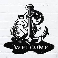 a welcome sign on a brick wall with an anchor in the center and octopus around it