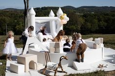 children and adults are gathered around an inflatable castle