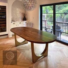 a large wooden table sitting in the middle of a living room next to a sliding glass door