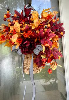 a basket filled with lots of flowers sitting on top of a door