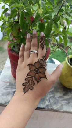 a woman's hand with henna tattoos on it