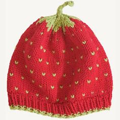 a knitted strawberry hat is shown on a white background, with green trim around the brim