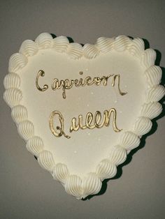 a heart shaped cake with the words capricon queen written in cursive writing