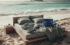 there is a bed on the beach with a laptop in front of it and a cruise ship in the background