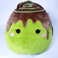 a green and brown stuffed toy with eyes