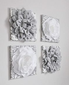 four pieces of art hanging on the wall with white flowers in each piece and grey damask