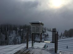 a bird house sitting on top of a snow covered hill next to a ski slope