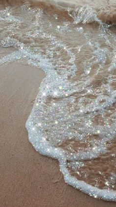 an ocean beach with sparkling sand and water