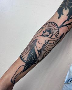 a man's arm with an egyptian style tattoo on the left side of his arm