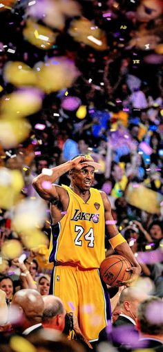 a man holding a basketball in his right hand and confetti falling around him