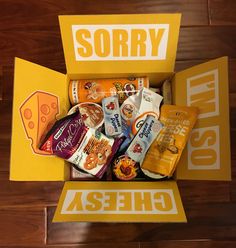 a box filled with assorted snacks sitting on top of a wooden floor