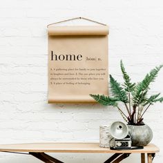 a wooden table topped with a potted plant next to a sign that says home