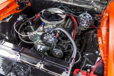 the engine compartment of an orange classic car