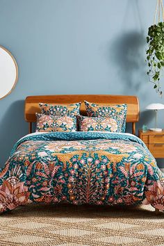 a bed in a bedroom with blue walls and floral comforter on top of it