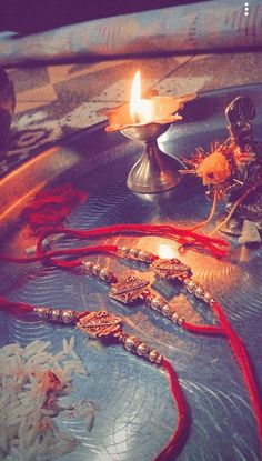 a candle that is sitting on top of a table with beads and other items around it