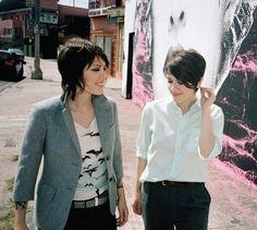 two women are walking down the street together