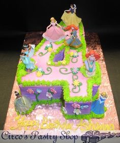 a birthday cake with princess figures on it