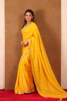 Beautiful yellow embroidered Banarasi Khaddi saree is a perfect choice for weddings and festive occasions! The saree has a beautiful embroidered border. It comes with a saree blouse. Disclaimer: The actual product may vary slightly from the image. These are custom orders, hence expect slight variation in color, placement of the motif or buta. ESTIMATED DELIVERYBecause this is a custom order, it would take about 4 weeks from the date of purchase. RETURN POLICYThis product is a custom order and cannot be returned or exchanged. Yellow Pre-draped Saree With Resham Embroidery, Yellow Chinon Pre-draped Saree, Yellow Pre-draped Saree For Festivals, Yellow Georgette Pre-draped Saree With Pallu, Yellow Pre-draped Saree With Zari Work, Yellow Pre-draped Saree For Navratri, Bollywood Style Yellow Pre-draped Saree For Navratri, Yellow Bollywood Pre-draped Saree For Navratri, Traditional Drape Yellow Pre-draped Saree For Navratri