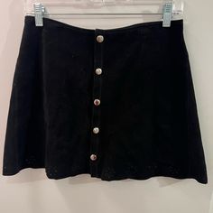 Suede Black Button Skirt With Floral Cutouts. Never Worn Chic Skort With Button Closure For Day Out, Casual Mini Skirt With Button Closure For Night Out, Trendy Skirt With Buttons For Night Out, Trendy Button Skirt For Night Out, Button Closure Mini Skort For Day Out, Chic Button Closure Skort For Day Out, Black High Waist Mini Skirt With Buttons, Black Mini Skort With Buttons, High Waist Black Mini Skirt With Buttons