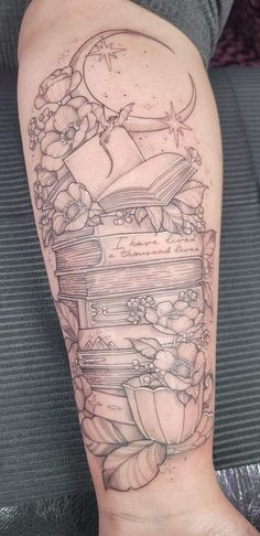 a person with a tattoo on their arm that has books stacked up in the middle