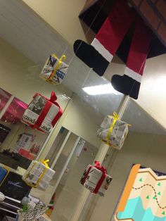 some christmas presents hanging from the ceiling in an office cubicle with santa's hat on top