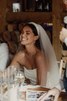 a bride and groom smile as they sit at a table