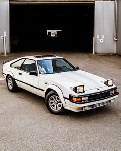 a white car parked in front of a garage