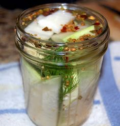 a mason jar filled with cucumber and herbs