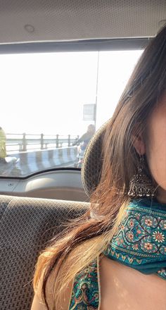 a woman sitting in the back seat of a car holding a cell phone to her ear