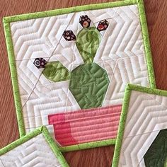 three quilted potted plants sitting on top of a wooden table