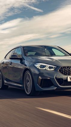 a grey bmw car driving down the road