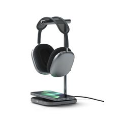 an electronic device with headphones attached to it's charging stand on a white background