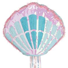 a pink and blue parasol sitting on top of a white table next to a glass vase