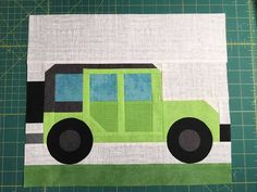 a close up of a piece of fabric on a cutting board with a green and black truck