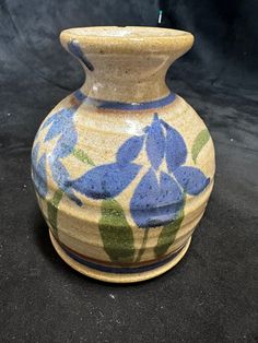 a vase with blue flowers painted on it