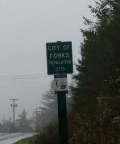 a street sign that reads city of forks population