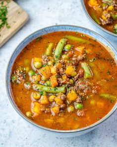 two bowls of vegetable soup on a table