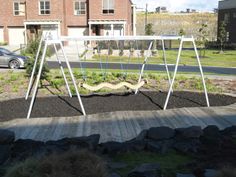 an empty swing set in the middle of a yard