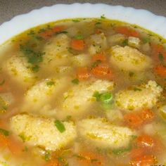 a bowl of soup with meatballs and carrots