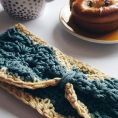 there is a crocheted dishcloth on the table next to a plate with a donut