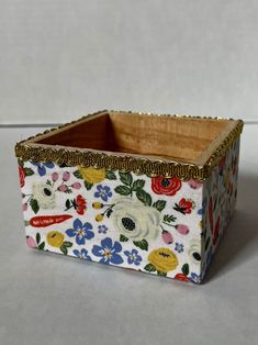 a small box with flowers on it sitting on a table