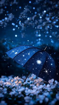 an open blue umbrella sitting on top of snow covered ground next to flowers and stars