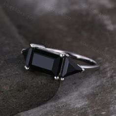 a black stone ring sitting on top of a rock