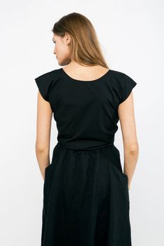 An artfully engineered top built for versatility and adaptability. This blouse can be worn with the knot in the front or the back, and also works wonderfully layered over tanks and dresses. Try tying it loosely for a relaxed fit, or tightly for a waist-cinching, pin-up silhouette. It boasts a low v-neck front- or full coverage in front with a low v-open back. Try tying the knot around the center front or back of your bra to help disguise it and keep the top securely in place. Simple rolled hems Summer V-neck Top With Knot Detail, Versatile Wrap Top With Tie Waist, Summer Cotton Blouse With Tie Back, Cotton Wrap Top For Summer, Summer Cotton Tie Back Blouse, Summer V-neck Top With Tie Waist, Casual Summer Blouse With Tie Waist, Casual Wrap Top For Day Out, Relaxed Fit Scoop Neck Crop Top For Summer