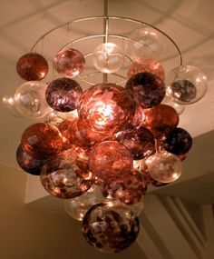 a chandelier made out of glass balls hanging from the ceiling in a room