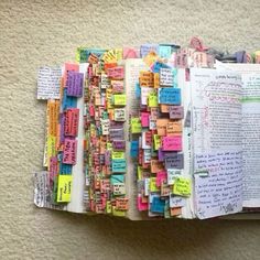 an open book covered in lots of different colored notes and writing on top of each other