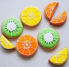 several decorated cookies with different colors and designs on them are arranged in the shape of fruit slices