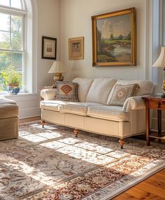 a living room filled with furniture next to a large painting on the wall above a window